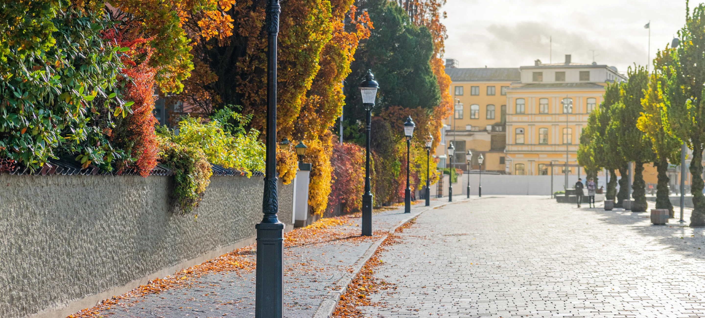Älvpromenaden med kullersten mot stadshotellet i höstinramning