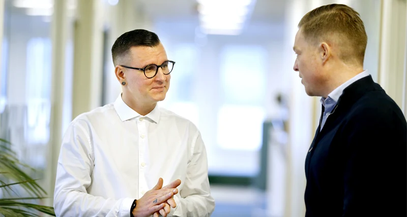 Två personer samtalar i en korridor