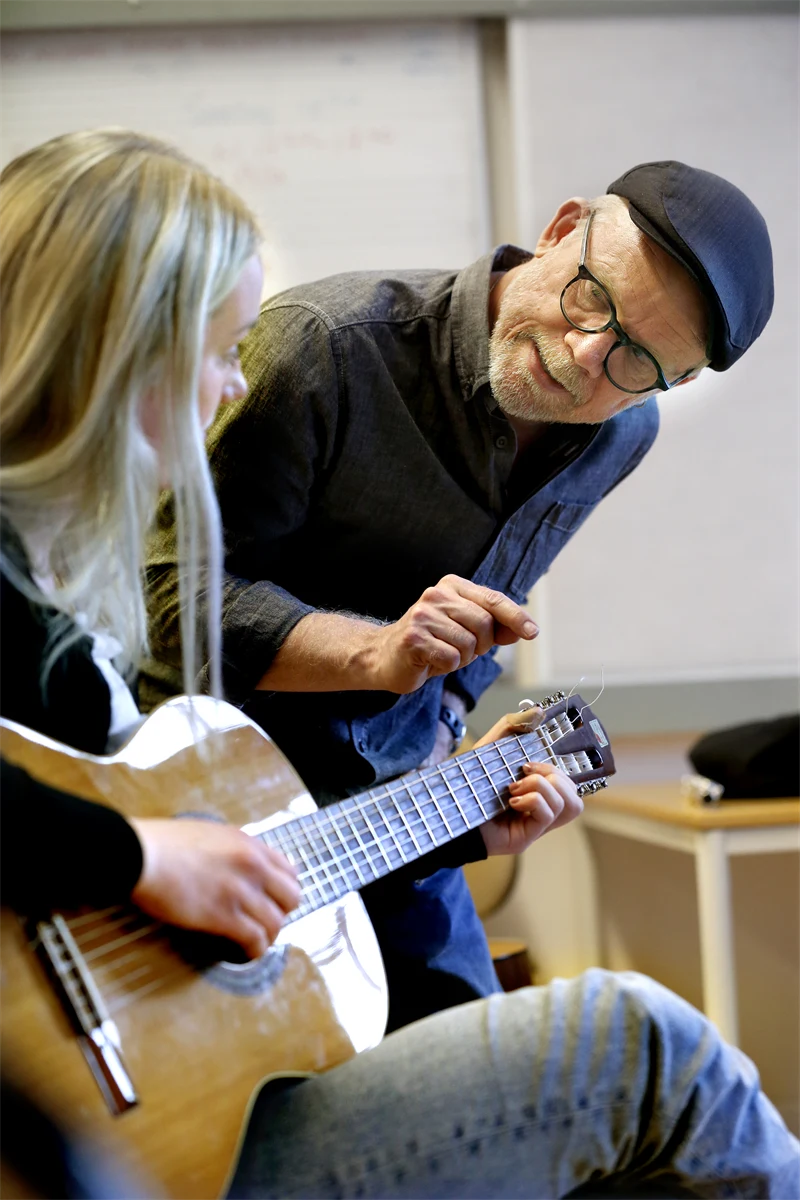 Musiklärare och en elev med gitarr