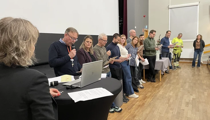 Flera personer på rad  framme vid en scen.