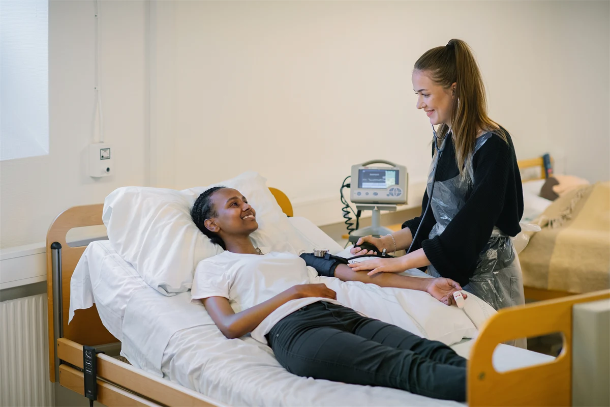 En gymnasieelev övar på att ta blodtryck på en annan gymnasieelev.