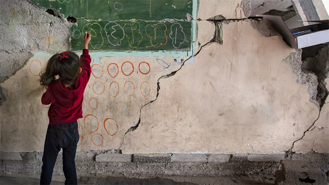 Flicka skriver på stenvägg.