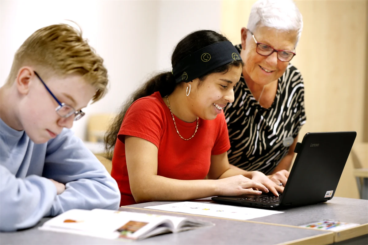 Skolbarn och lärare tittar på en datorskärm i skolmiljö