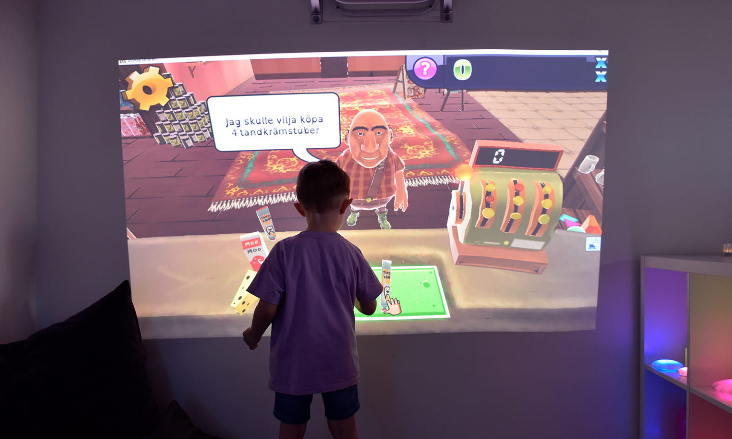 Förskolebarn leker affär i en digital skärm