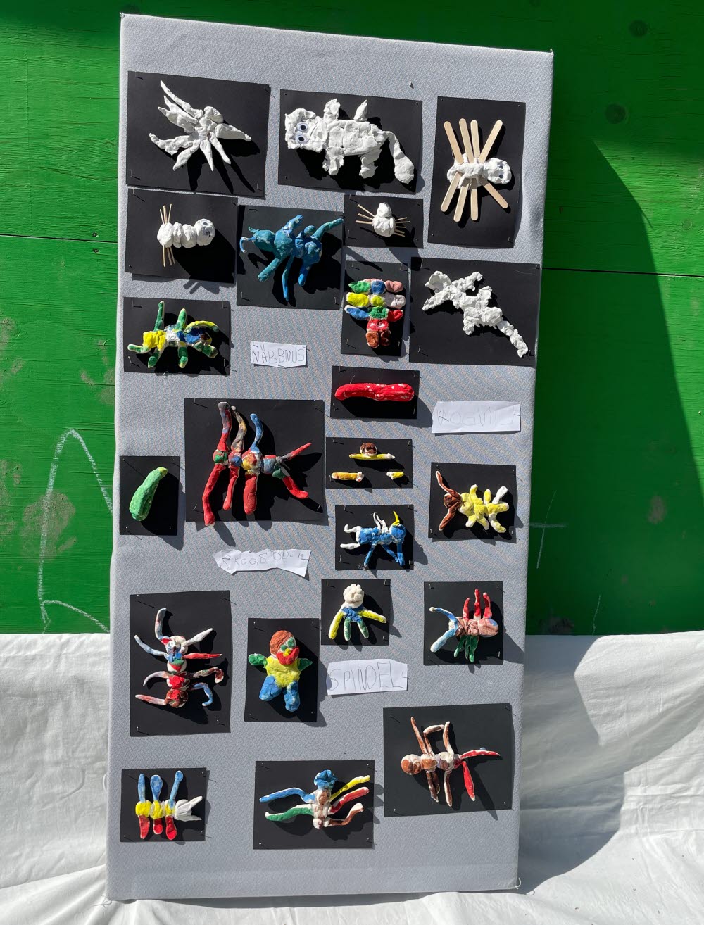 Lerfigurer som föreställer färgglada insekter