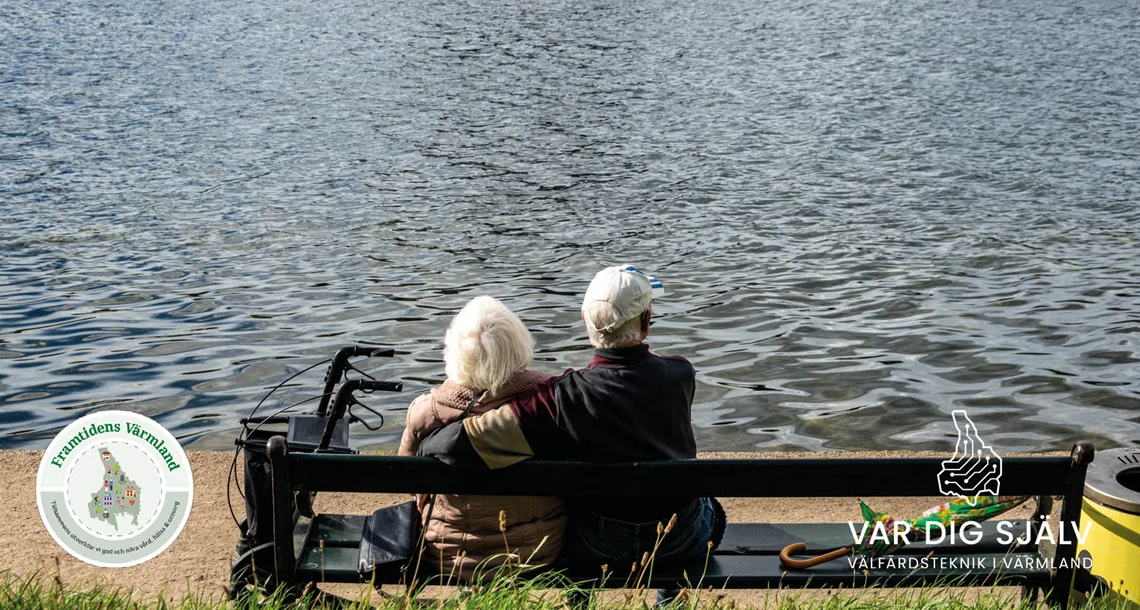Två pensionärer som sitter på en bänk i solen och tittar ut över vatten
