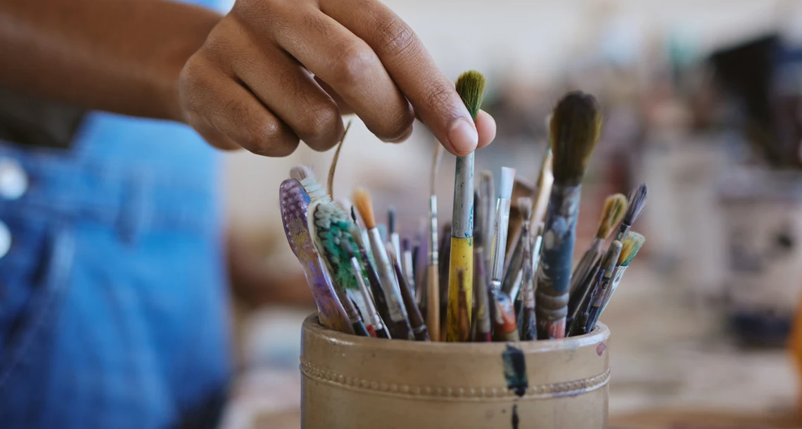 Hand som tar en pensel