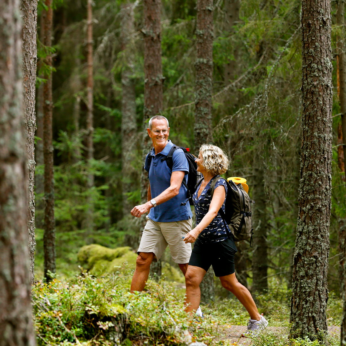 En man och en kvinna vandrar i skogen på Jäverön.