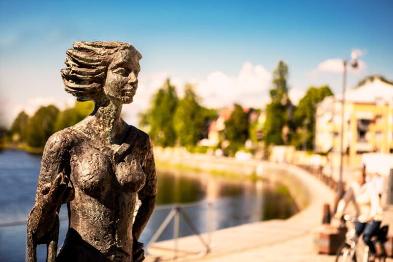 Staty vid Klarälven med Stadshotellet i bakgrunden