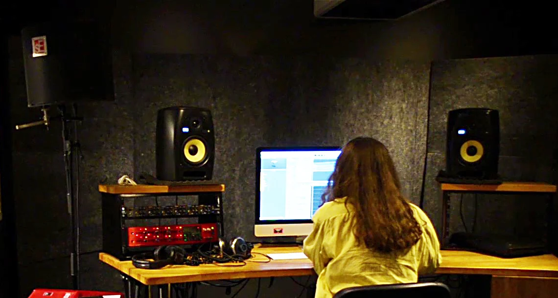 En person sitter vid studiodator och redigerar