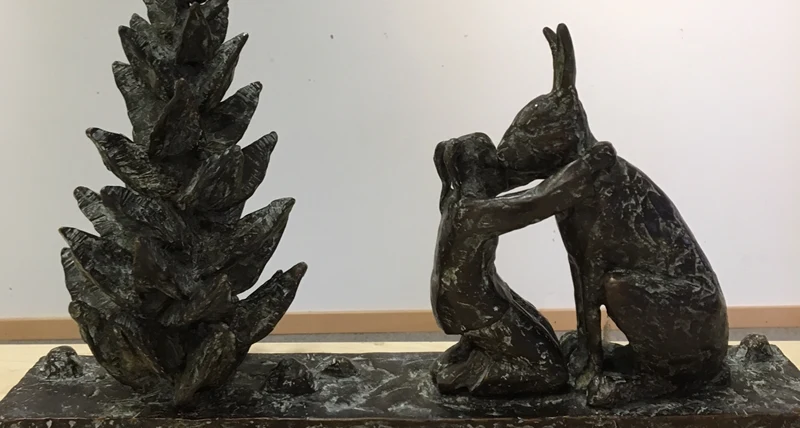 Skulptur med flicka som kramar en hare