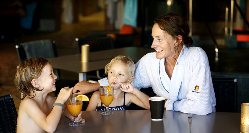 En mamma med två barn vid ett cafébord