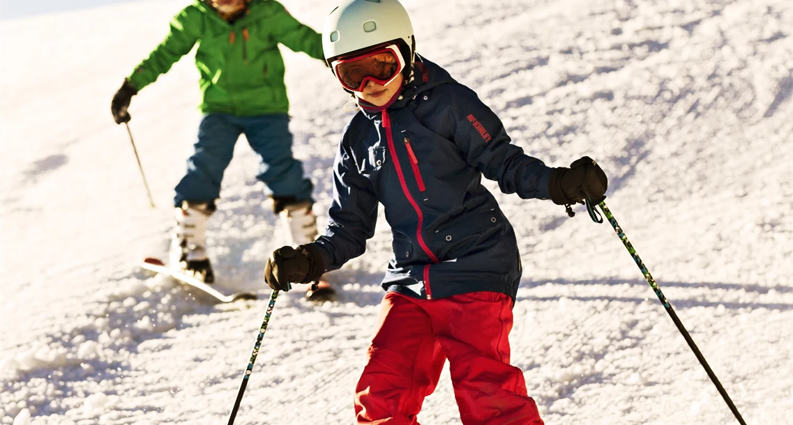 Två barn åker slalom
