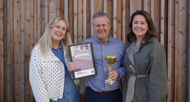 Rektor ulf håller upp pokal och diplom och fotas bredvid UF Värmlands projektledare