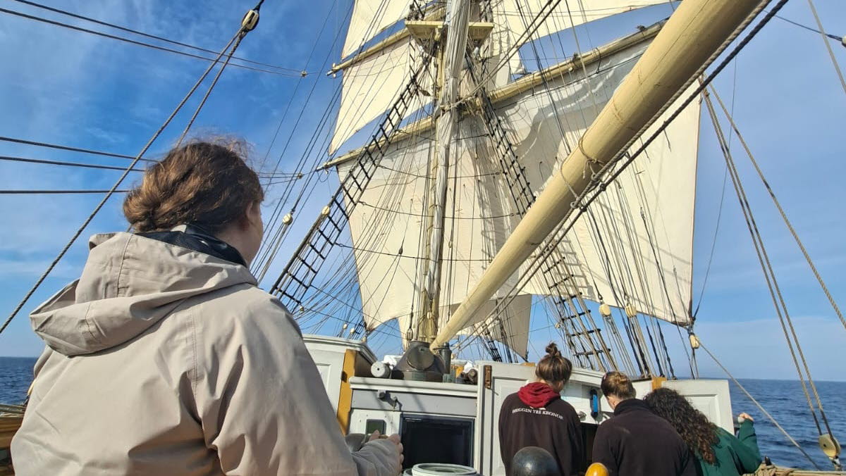 Sabrina styr en segelbåt och tittar ut mot horisonten.