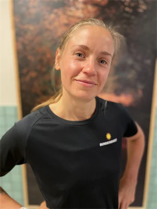 En kvinnlig massör tittar mot kameran