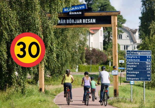 Bild på familj som cyklar vid Klarälvsbanan med en inklipp skylt som visar 30 km/h