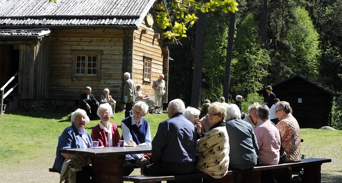 Pensionärer som sitter  på bänken i parken