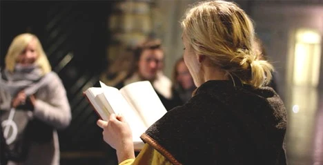 Bild på kvinna som läser från en bok