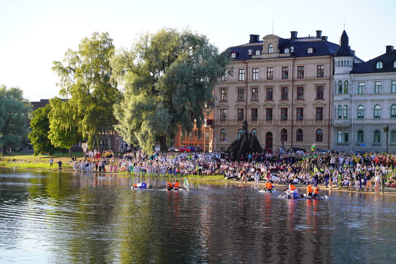 Massor av folk i centrala Karlstad kollar på flottrace i Klarälven.