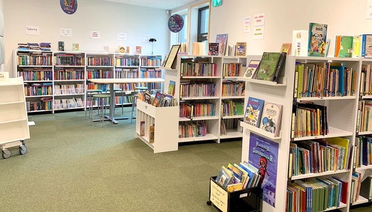 Tre hyllor som är fyllda med böcker