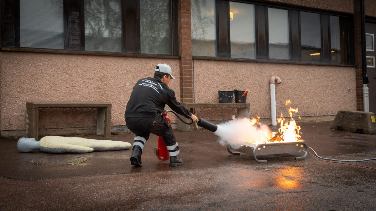 Elev tränar på att släcka en brand med brandsläckare