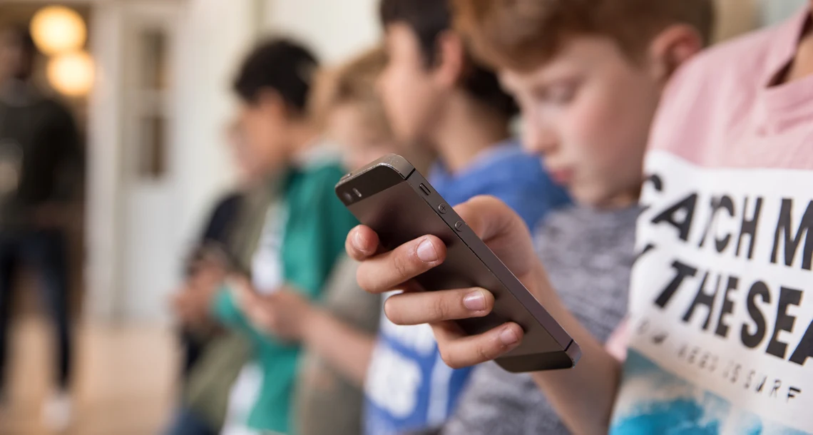 Elever som tittar i mobilen i skolmiljö