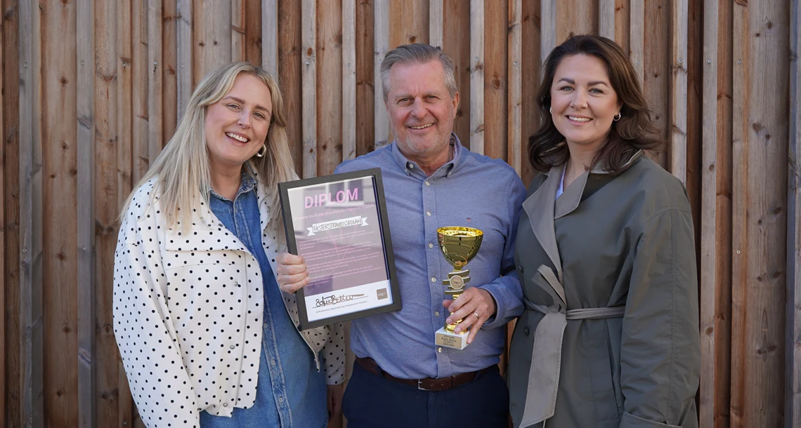 Rektor ulf håller upp pokal och diplom och fotas bredvid UF Värmlands projektledare