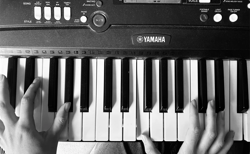 Två händer som spelar piano, svartvitt