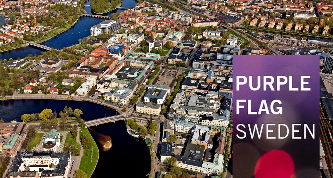 En flygbild över en stads centrum. Till höger ses en logotype med texten Purple Flag Sweden