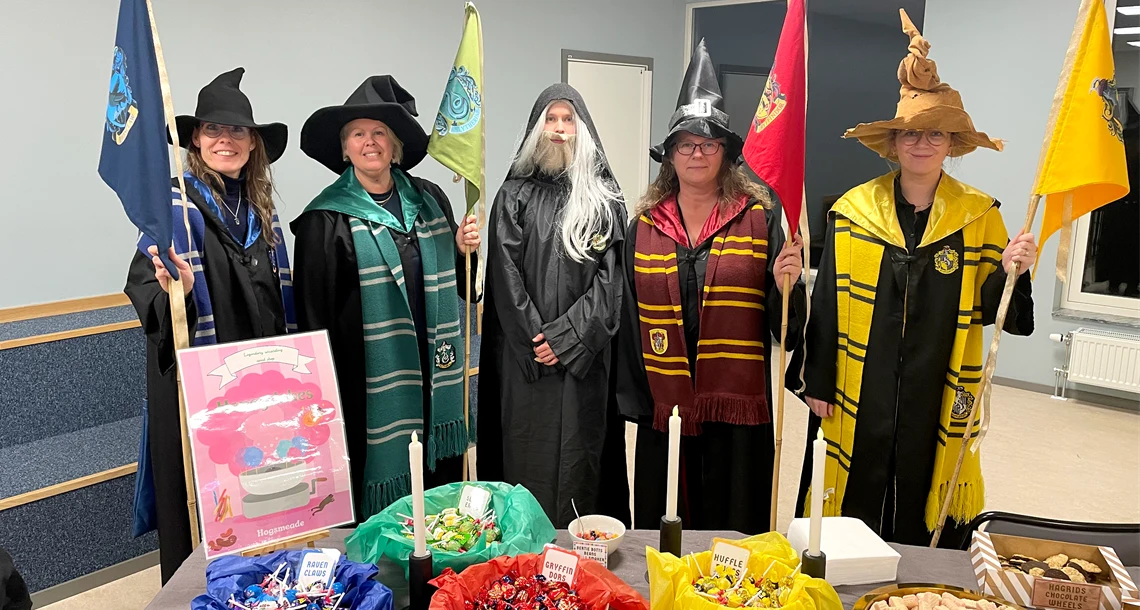 Fem lärare som är utklädda till Harry Potter karaktärer i färgglada dräkter. 