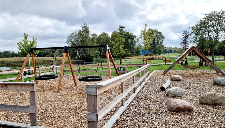 Skolgård med gungor, stenar och en klättervägg
