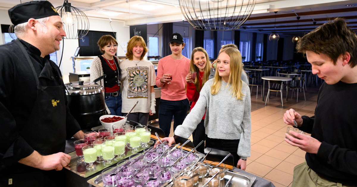 Elever och kockar vid en frukostbuffe i ett skolkök