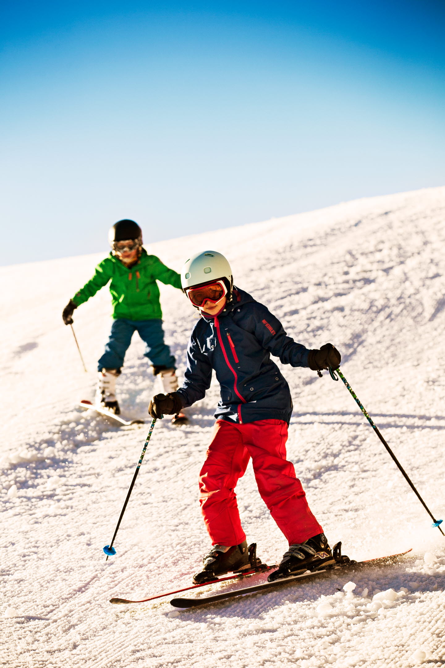 Två barn åker slalom i Bryngfjordens slalombacke.