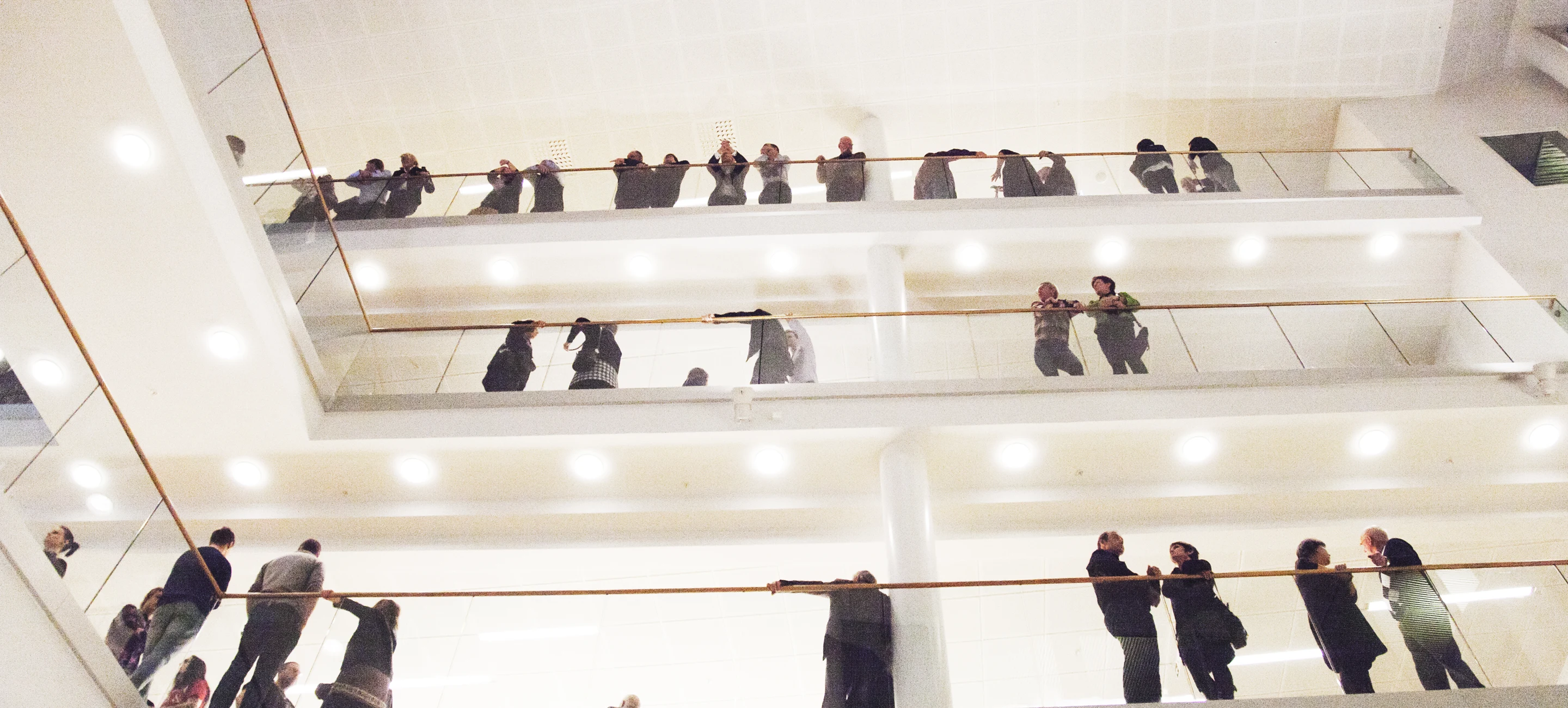 Människor som minglar på olika våningar i ett konferenscenter