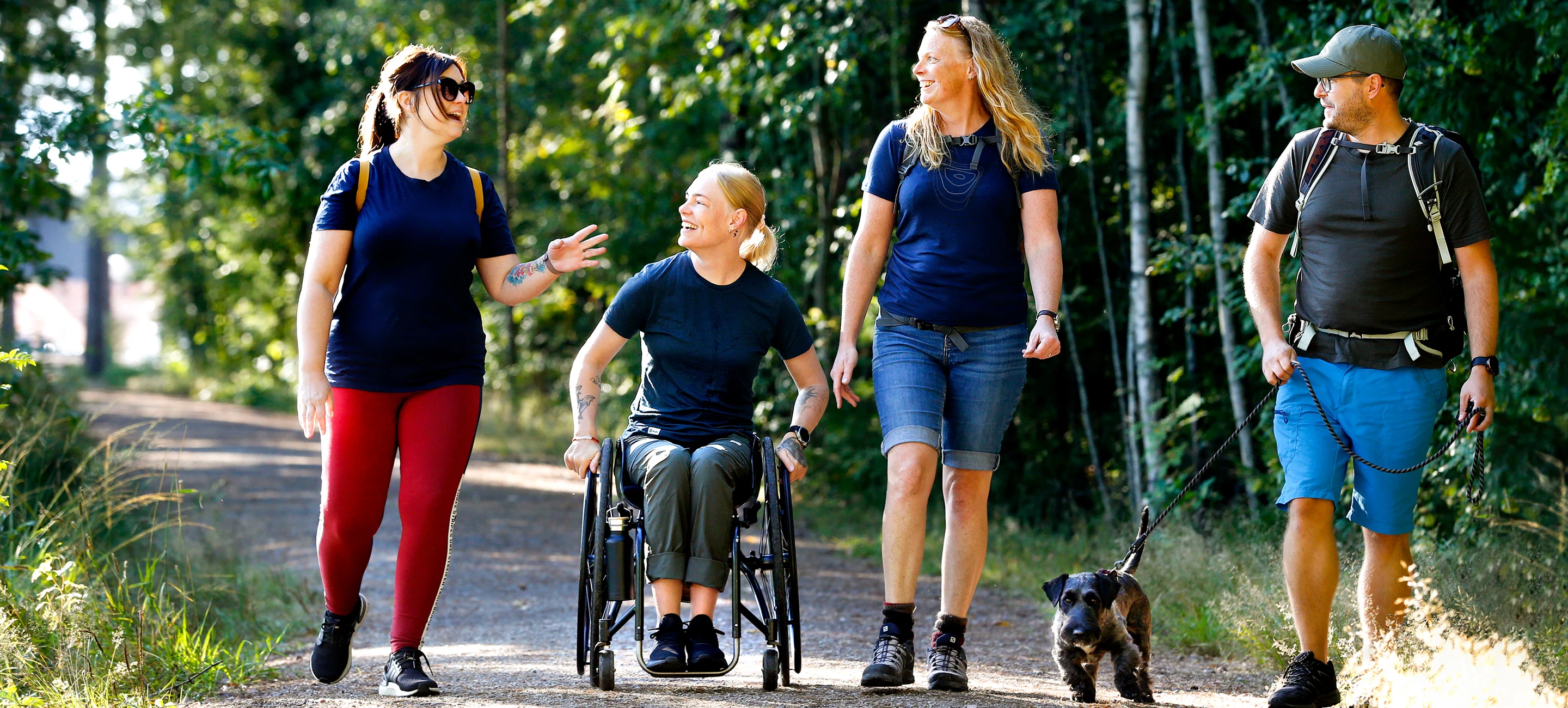 Fyra personer och en hund på vandringsled