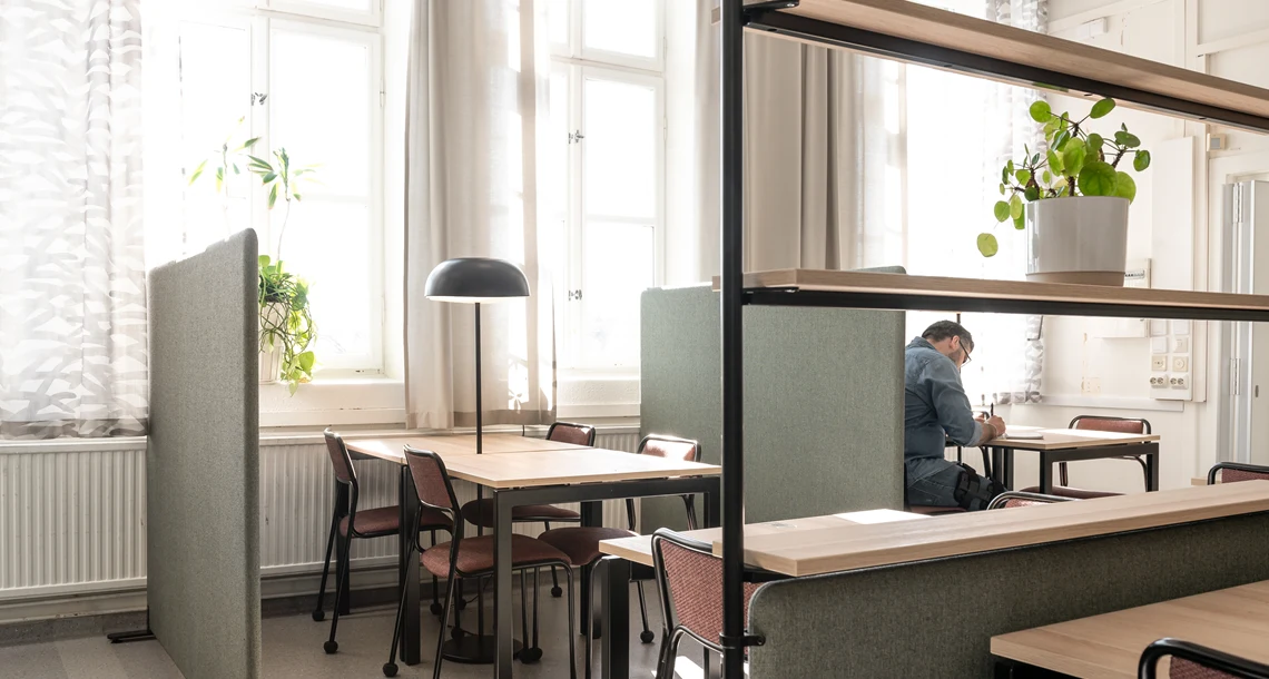 Studiemiljö på Lärcenter med stolar och bord. En elev studerar.