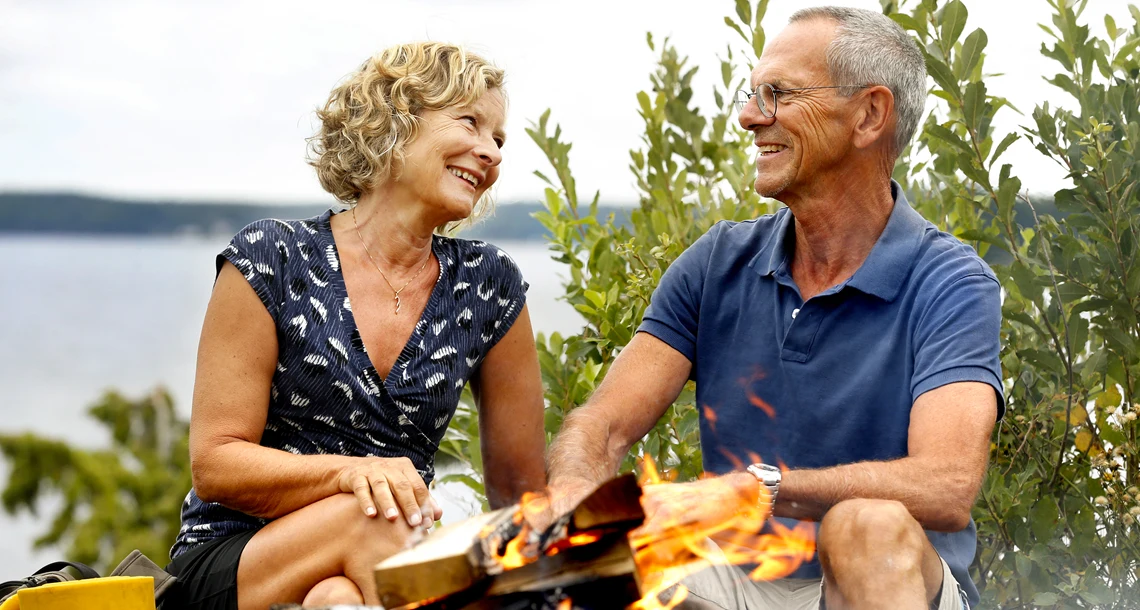En man och en kvinna grillar på Rävön. De tittar på varandra.